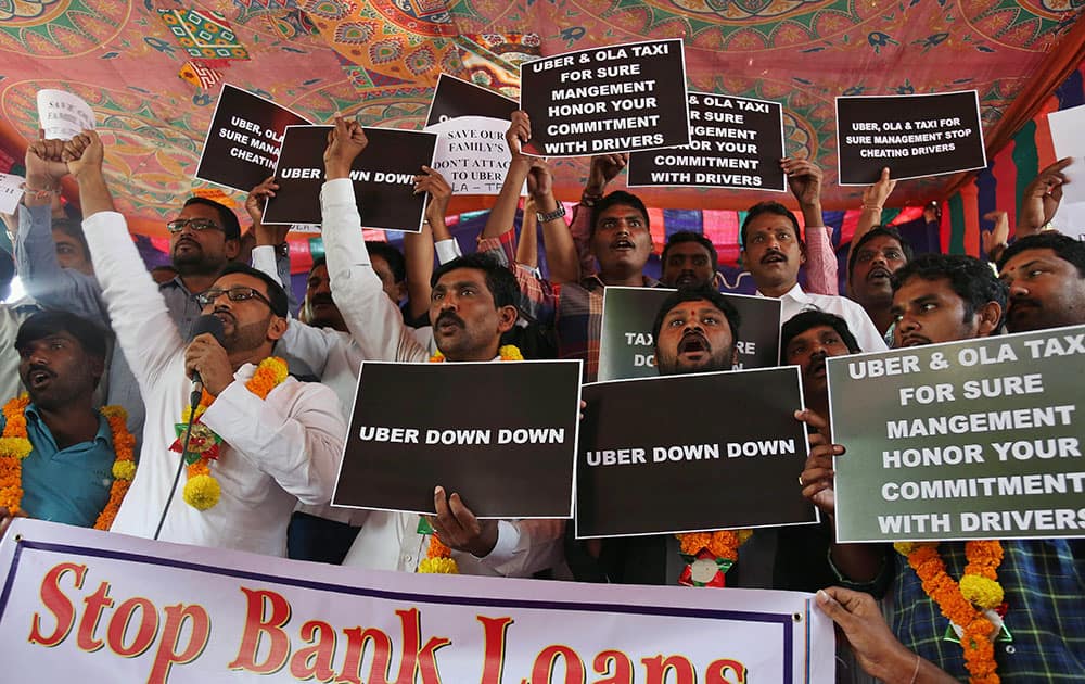 Telangana Cabs and Bus Operators' Association (TCBOA) President Syed Nizamuddin, holding a microphone, along with others shouts slogans during a one-day hunger strike against the ride-hailing service Uber in Hyderabad.