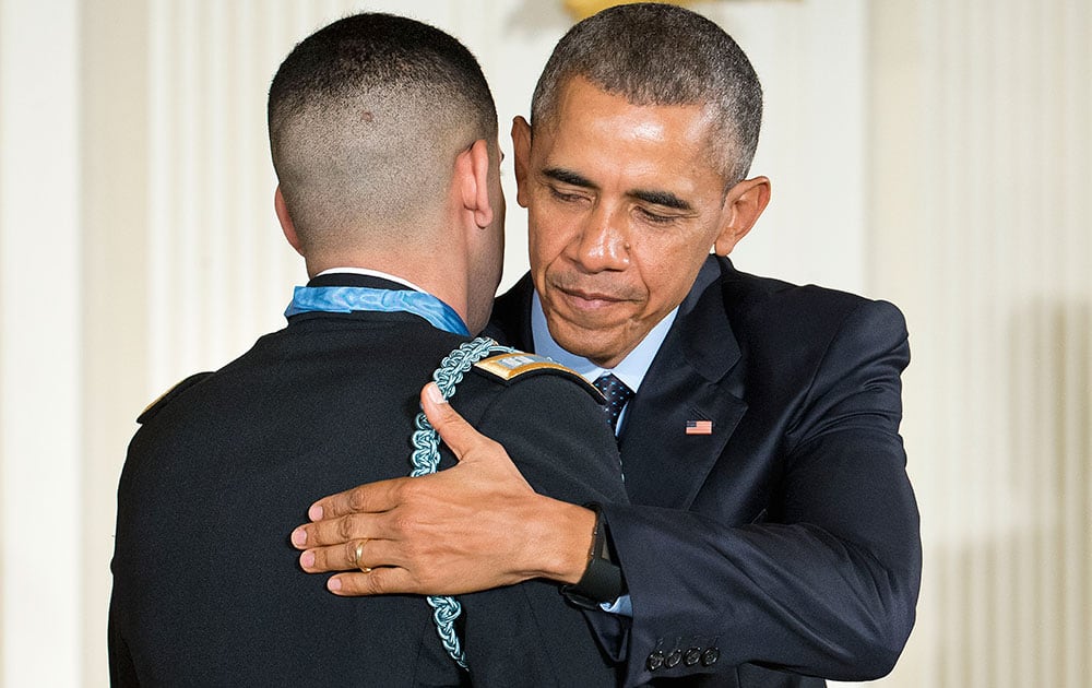 President Barack Obama and Florent Groberg embrace after Obama bestowed the nation's highest military honor, the Medal of Honor to Groberg, during a ceremony in the East Room of the White House in Washington.