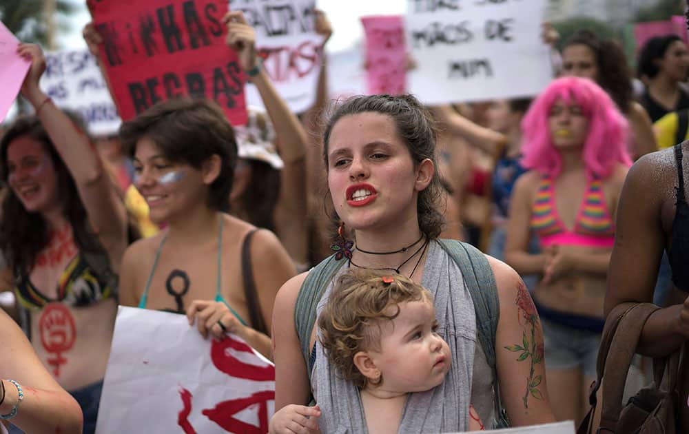 A woman carries her baby during the annual Slutwalk in Rio de Janeiro, Brazil.