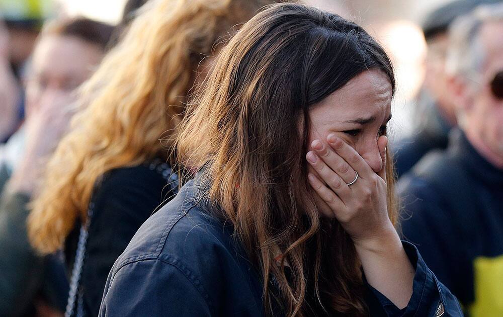 A woman cries outside the restaurant on Rue de Charonne, Paris.
