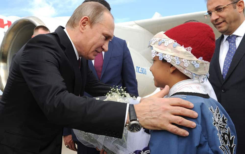 Russian President Vladimir Putin, left, is greeted by children as he arrives at Antalya International Airport in Antalya.