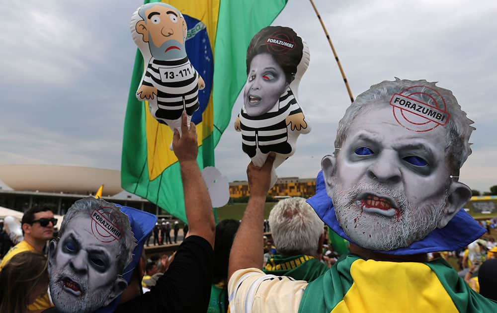 Demostrators with masks of Brazil's former President Luiz Inacio Lula da Silva carry dolls during protest against Brazil's President Dilma Rousseff, in front of the Brazilian National Congress, in Brasilia, Brazil.