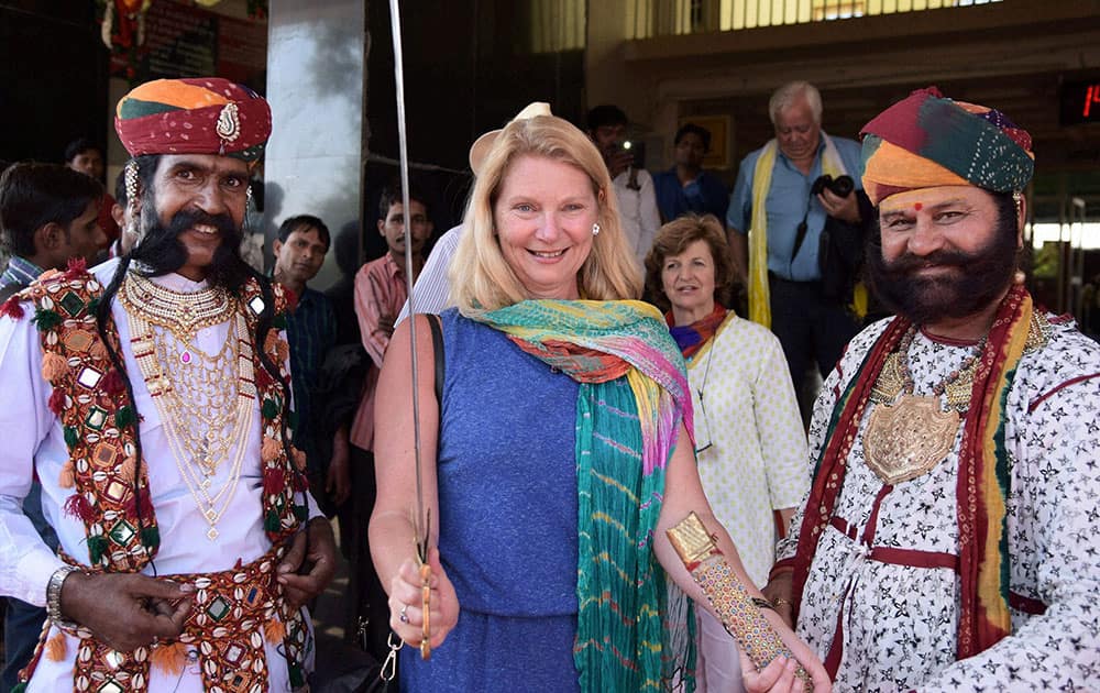 Rajasthani artists pose for a photo with foreign tourist in Bikaner.