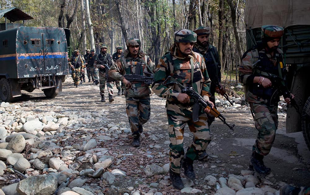 Army soldiers patrol near the site of a gunbattle with suspected rebels in Bungham village, northwest of Srinagar.