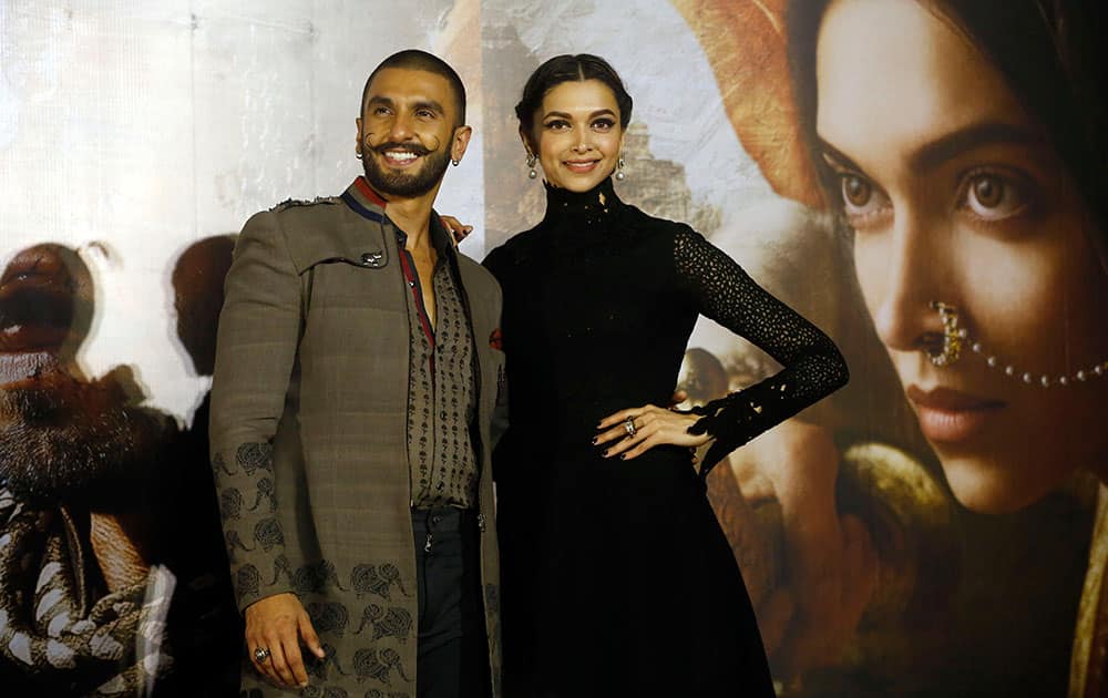 Bollywood actors Ranveer Singh and Deepika Padukone, right, pose for photographers during a trailer launch of their movie Bajirao Mastani in Mumbai.