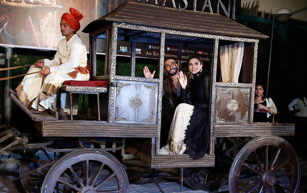 Bollywood actors Ranveer Singh and Deepika Padukone, right, pose for photographers during a trailer launch of their movie Bajirao Mastani in Mumbai.