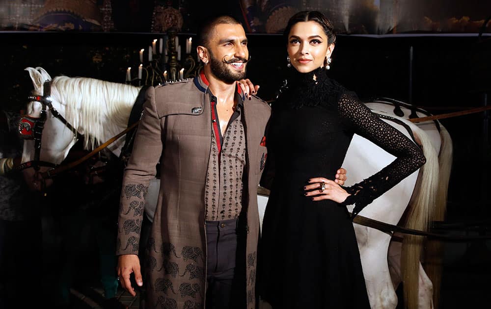 Bollywood actors Ranveer Singh and Deepika Padukone, right, pose for photographers during a trailer launch of their movie Bajirao Mastani in Mumbai.