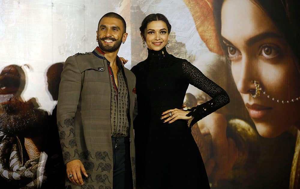 Bollywood actors Ranveer Singh and Deepika Padukone, right, pose for photographers during a trailer launch of their movie Bajirao Mastani in Mumbai.