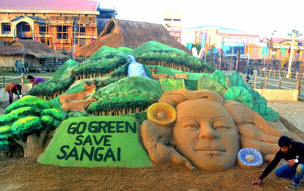 Renowned sand artist Sudarsan Pattnaik creating a sand sculpture with messageGo Green Save Sangai during Sangai Festival in Imphal in Manipur.
