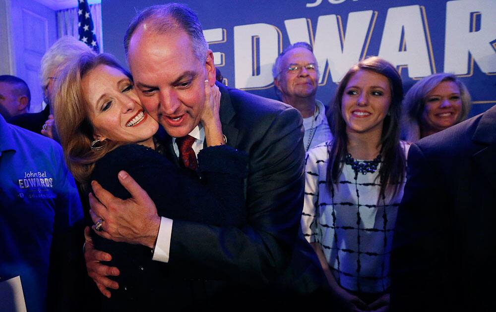 Louisiana Gov.-elect John Bel Edwards hugs his wife Donna Edwards as he arrives to greet supporters at his election night watch party in New Orleans. At right is his daughter Sarah Ellen Edwards.