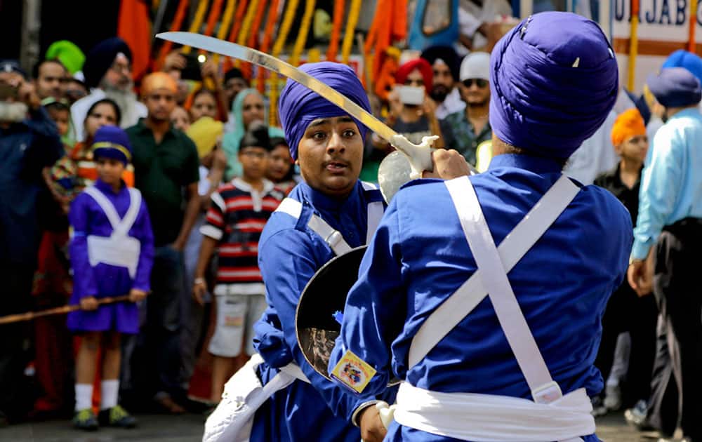 Sikh youth display their martial arts skills during a religious procession ahead of the birth anniversary of the first Sikh guru, Guru Nanak, in Kolkata.