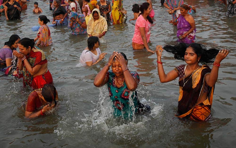 Hindu devotees perform religious rituals as they offer prayers to the Sun god while taking a dip in the river Yamuna on the auspicious occasion of Karthik Purnima in Allahabad.