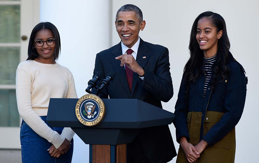 President Barack Obama, with his daughters, Sasha and Malia, speaks before he pardoned the National Thanksgiving Turkey Abe, during a ceremony in the Rose Garden of the White House in Washington.