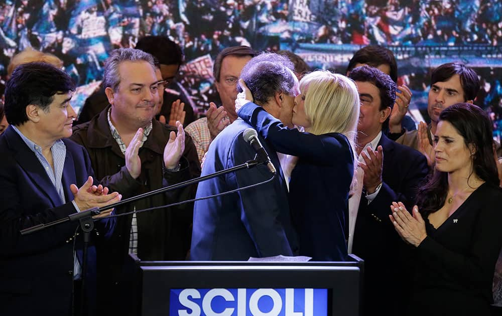 Daniel Scioli, the ruling party presidential candidate, is kissed by his wife Karina Rabolini, after delivering his concession speech during Argentina's presidential runoff election in Buenos Aires. Macri won Argentina's historic runoff election, putting an end to the era of President Cristina Fernandez, who along with her late husband dominated the political scene.