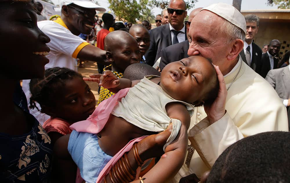 Pope Francis caresses a baby as he visits a refugee camp, in Bangui, Central African Republic.