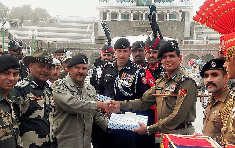 officials offer sweets to Pakistani Rangers officials during the golden jubilee celebrations of the Border Security Force (BSF) raising day at Indo-Pak Attari-Wagha border.