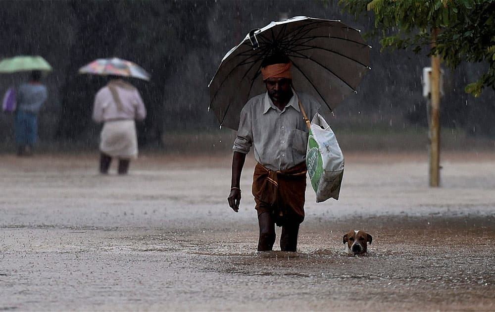 Visitors move from a flooded Government hospital after heavy rains in Chennai.