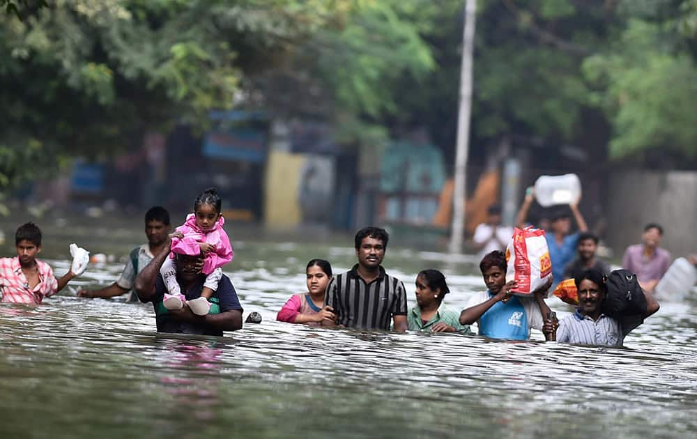 People wade through flood waters in rain-hit Chennai.