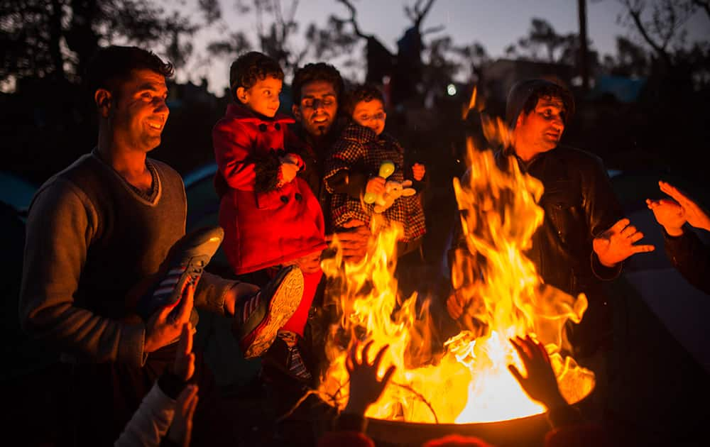 Members of several Afghan families try to warm up next to a bonfire outside a processing center in Moria village on the northeastern Greek island of Lesbos.