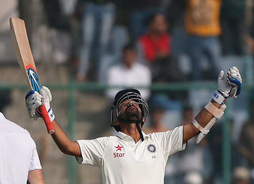 Ajinkya Rahane raises his bat and looks heavenwards after scoring a century against South Africa, on the second day of the fourth test match between the two countries, in New Delhi.