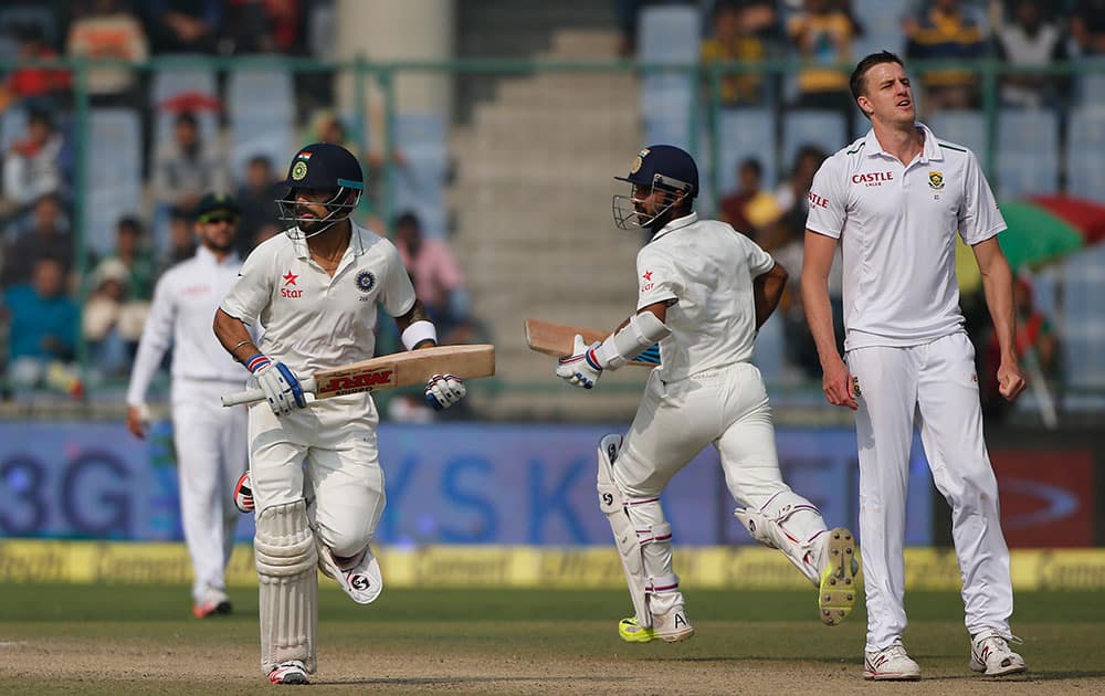 South African bowler Morne Morkel, right watches, Virat Kohli and Ajinkya Rahane, run between the wickets on the third day of the fourth test cricket match between India and South Africa in New Delhi.