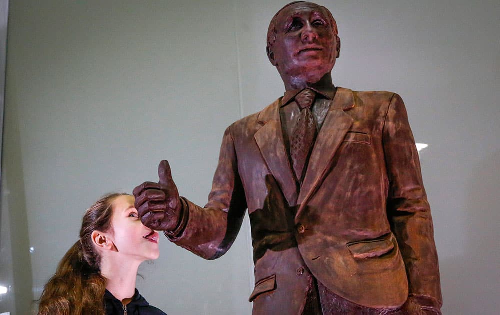 A girl tries to lick a chocolate statue of Russian President Vladimir Putin during the Chocolate Festival in St.Petersburg, Russia.