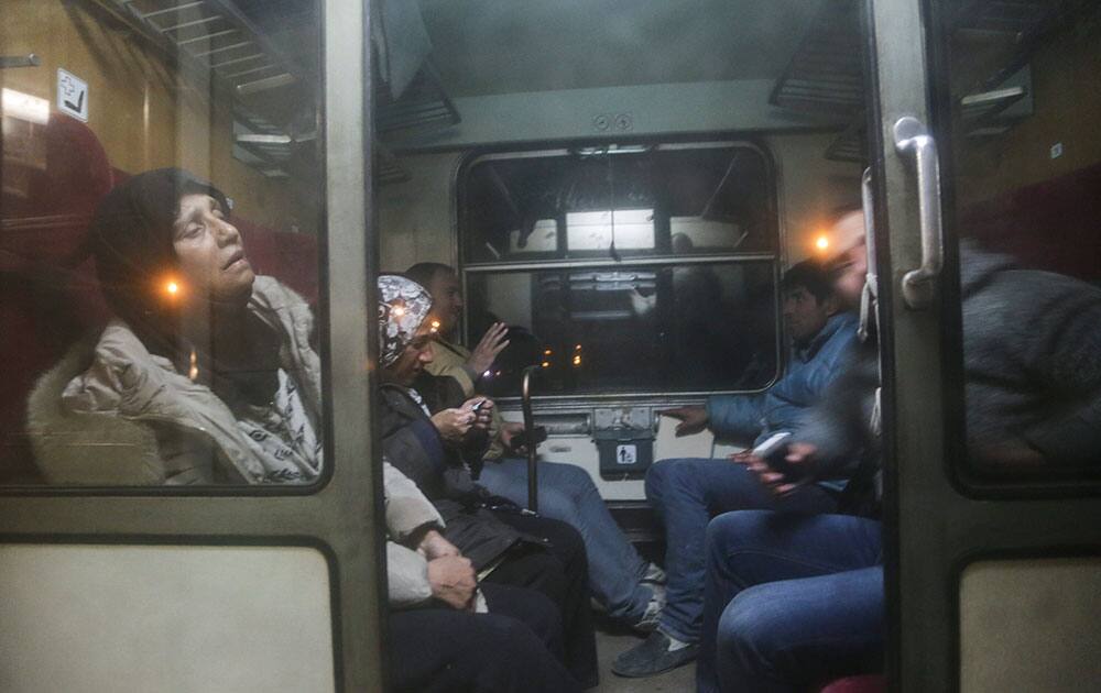 People sit on a train to Serbia near the southern Macedonian town of Gevgelija.  Macedonia is allowing only people from Afghanistan, Iraq and Syria to cross the border, and groups of people from other nationalities have set up makeshift roadblocks, preventing anyone from crossing. 