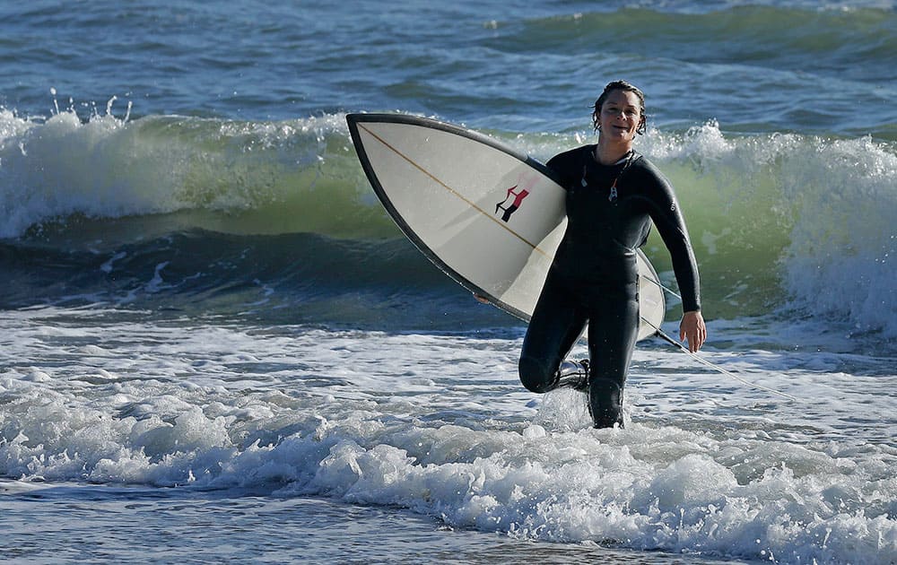 Bianca Valenti walks in from the ocean after surfing waves at Mavericks in Half Moon Bay, Calif. 