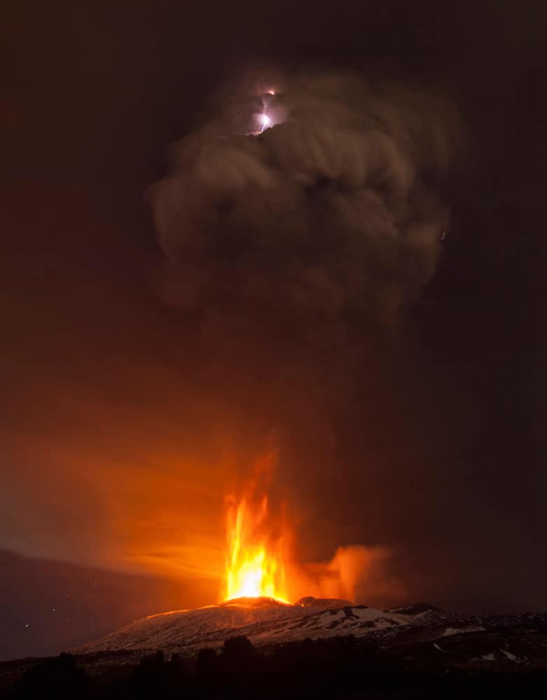 Lightning flashes inside a plume of smoke during an eruption of Mt. Etna near Catania, Italy.