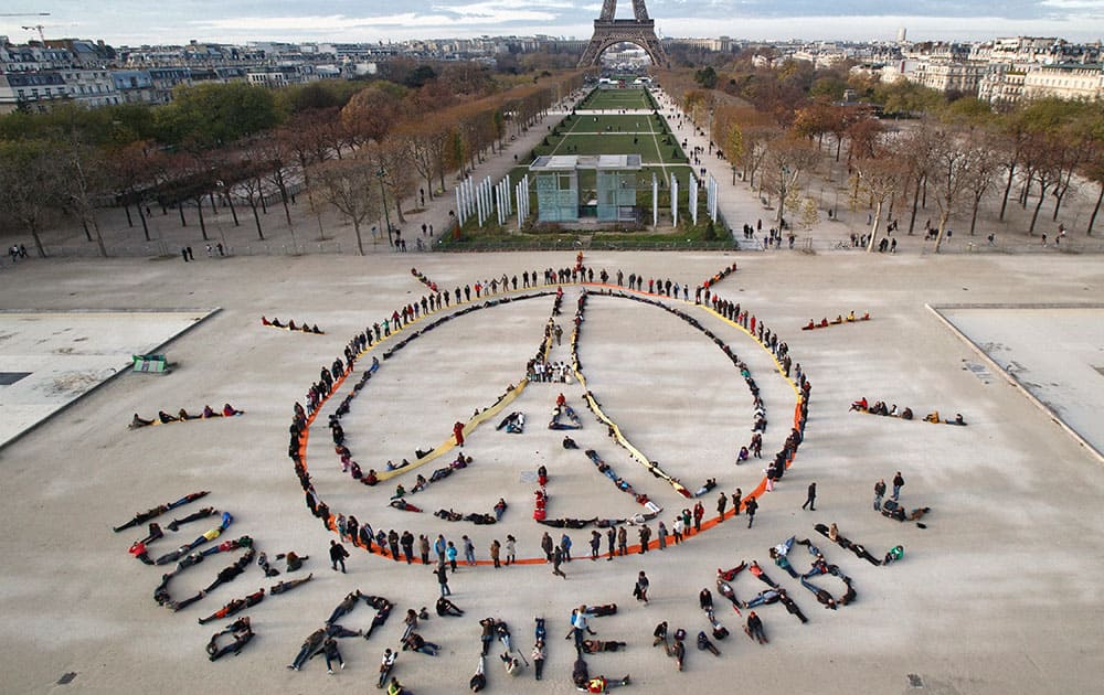 Environmentalist activists form a human chain representing the peace sign and the spelling out 100% renewable, on the side line of the COP21, United Nations Climate Change Conference near the Eiffel Tower in Paris.