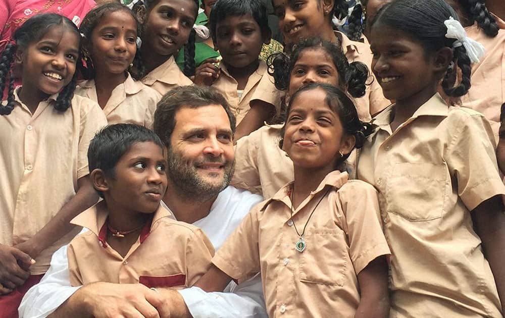 congress Vice President Rahul Gandhi with school children during his visit to flood affected areas in Cuddalore in Tamil Nadu.