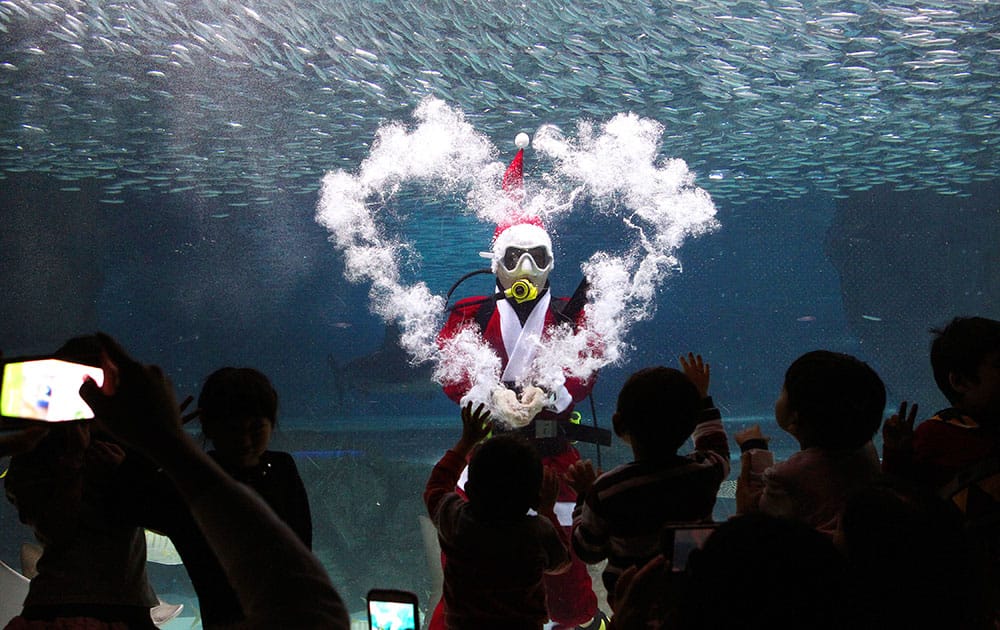 A diver dressed in a Santa Claus costume makes the heart-shape with bubbles at the Coex Aquarium in Seoul, South Korea.