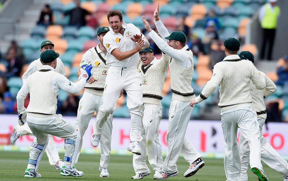 Australia's James Pattinson, center, celebrates with teammates after dismissing West Indies' Jermaine Blackwood during their cricket test match in Hobart, Australia.
