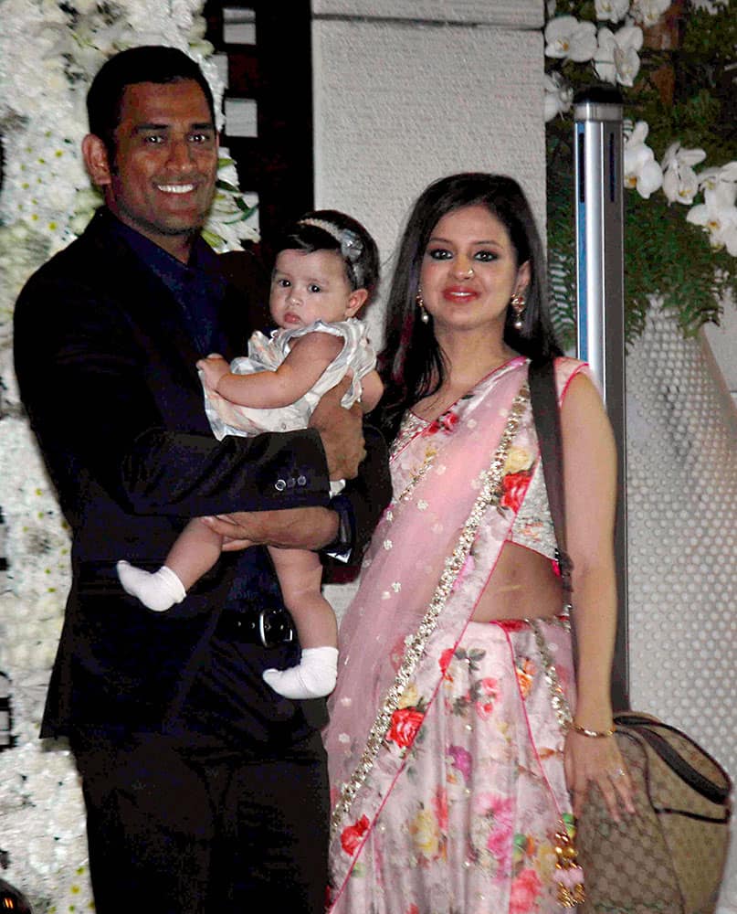 Cricketer Mahendra Singh Dhoni along with his wife Sakshi Dhoni and daughter Ziva during the wedding celebrations for cricketers Harbhajan Singh and Rohit Sharma.