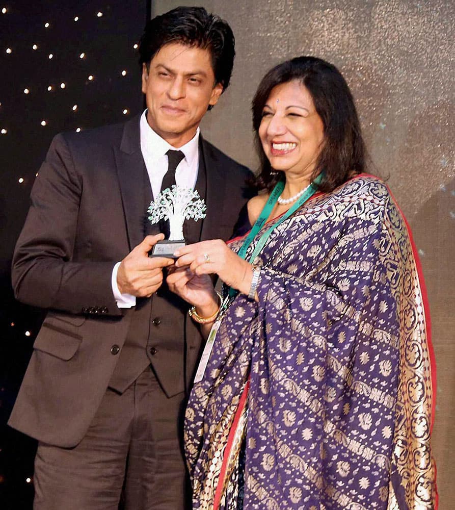 Biocon chief Kiran Mazumdar Shaw (R) presents a memento to Bollywood actor Shahrukh Khan at IIMBUE 2015 – IIMB Alumni Leadership Summit.