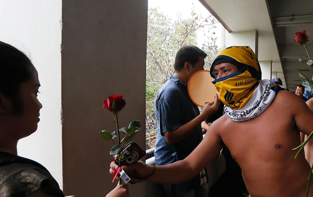A naked student hands a rose to a student as he and about two dozen members of the Alpha Phi Omega fraternity run naked around the Arts and Sciences building in the traditional 