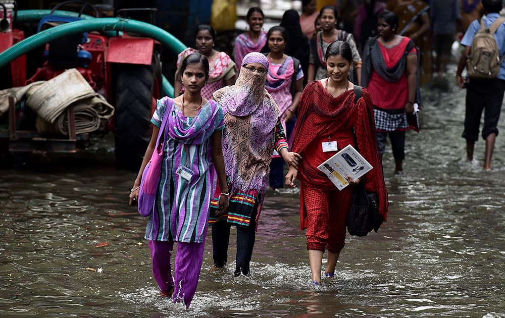 Girls going to college in Chennai as public and private schools and colleges reopened on Monday nearly after a month long shut following the devastating rainfall and floods.