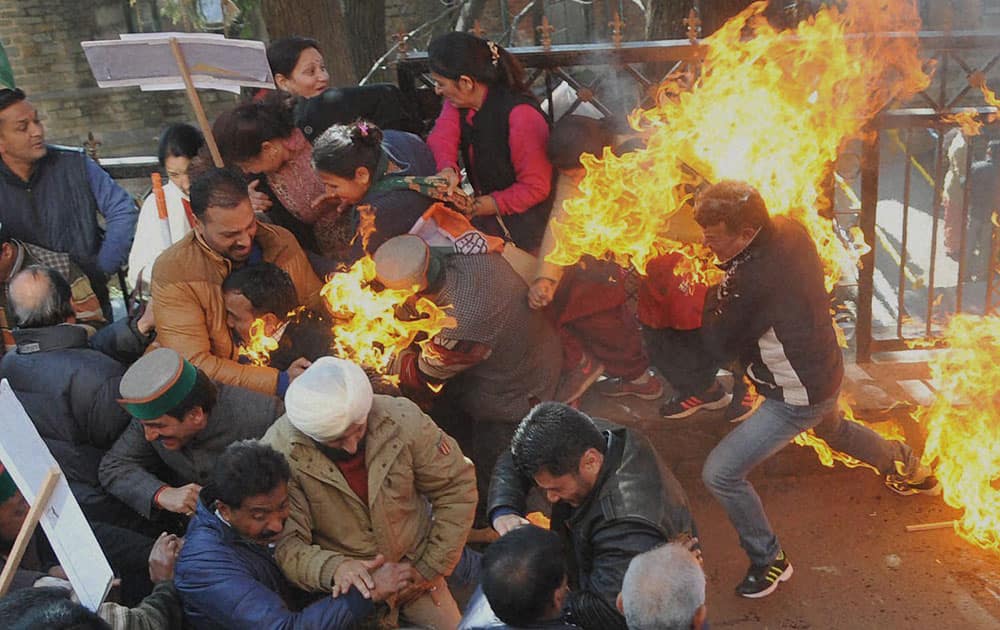 Activists of Congress party try to flee after their clothes caught fire while they were trying to burn an effigy of Prime Minister Narendra Modi during a protest in Shimla.