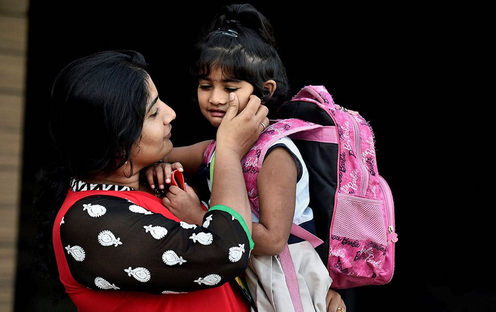 A student is carried to a school in Chennai as public and private schools reopened on Monday nearly after a month long shut following the devastating rainfall and floods.