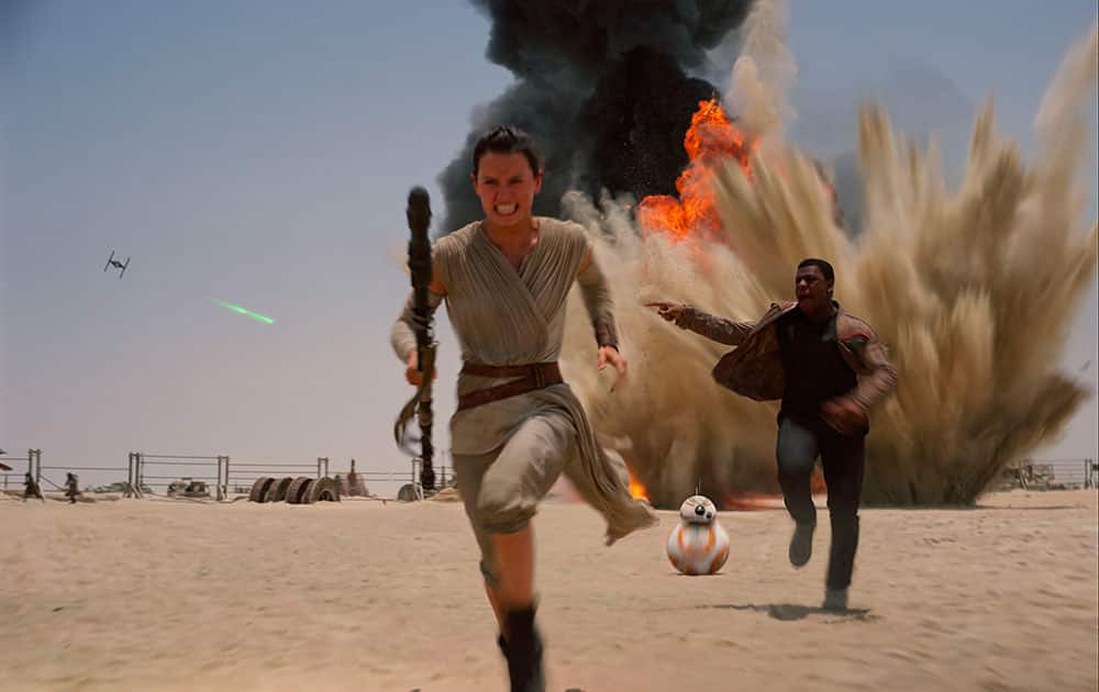 This photo provided by Disney shows Daisey Ridley as Rey, left, and John Boyega as Finn, in a scene from the new film, 