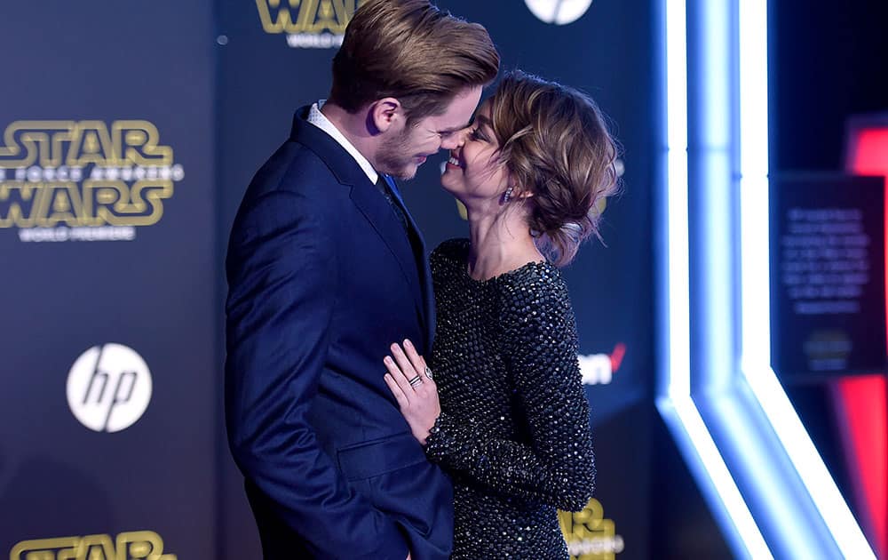 Dominic Sherwood, left, and Sarah Hyland kiss as they arrive at the world premiere of 