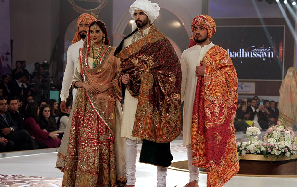 Models present creations by Pakistani designer Fahad Hussan during the last day of Telenor Bridal Couture Week in Lahore.