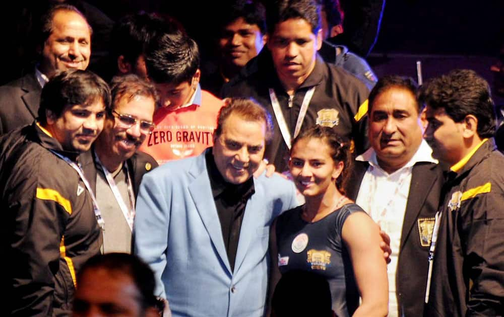 Actor Dhramendra poses for photographs along with wrestlers during the Pro-wrestling League in Ludhiana.