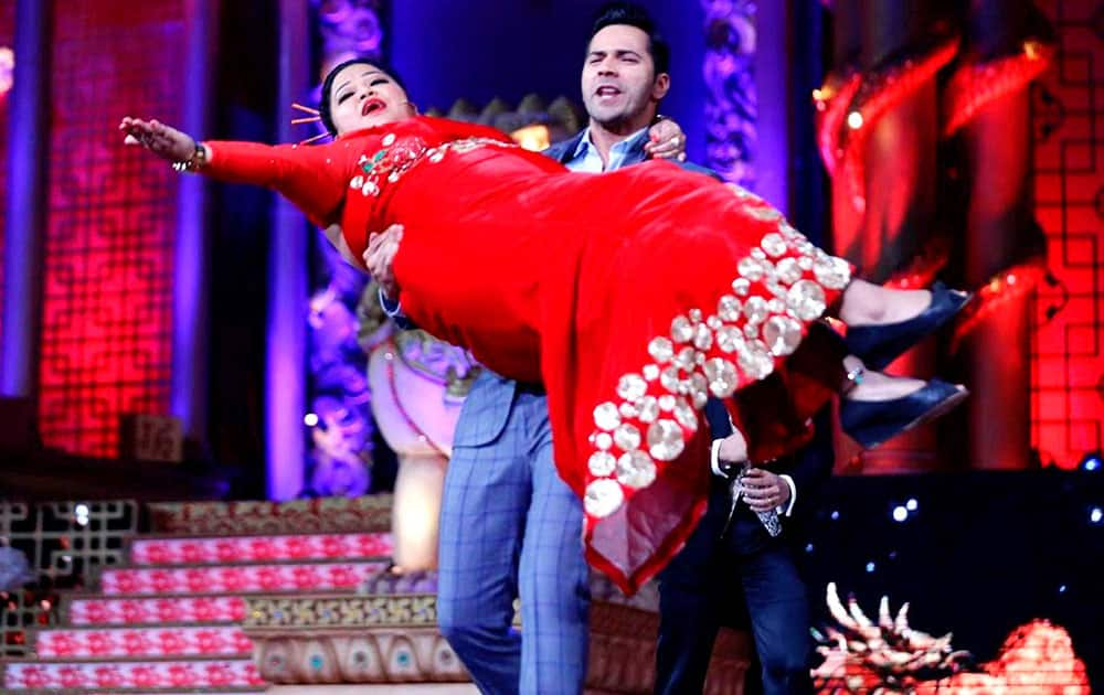 Actor Varun Dhawan performs with comedian Bharti during the Big Star Entertainment Awards event in Mumbai.