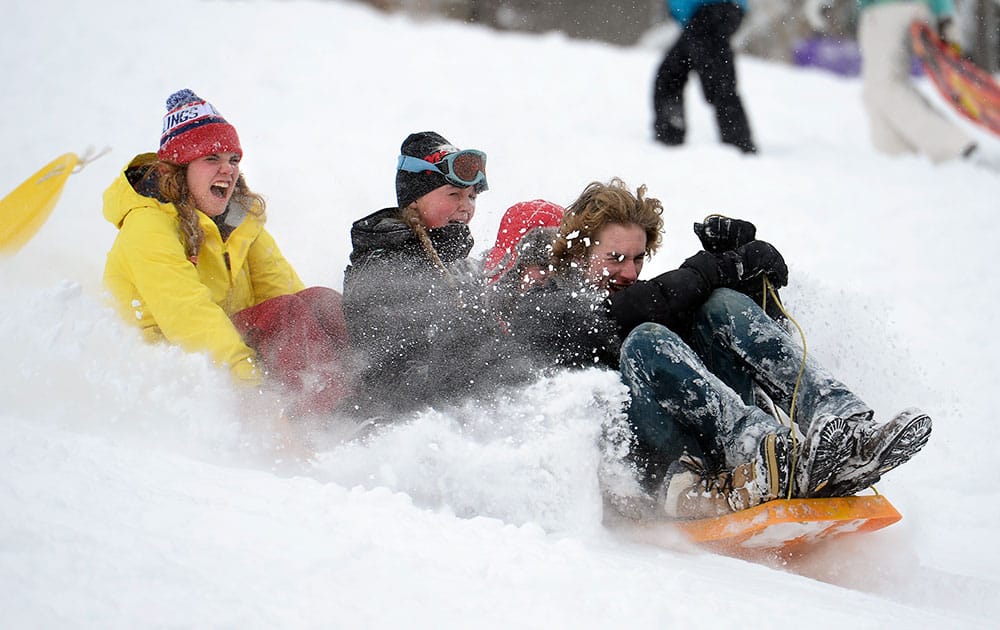 Maddie Werner, left, Abbie Olson, Maya Wilson and Storm Smith take a sleigh ride together in the fresh snow, at Tantra Park in Boulder, Colo. 