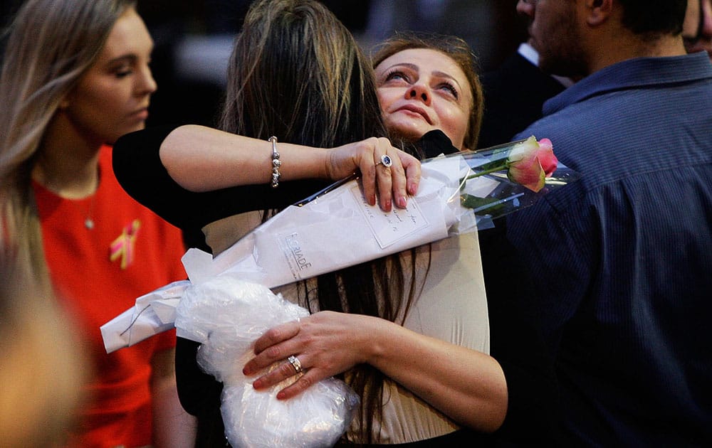 Lindt Cafe siege survivor Marcia Mikhael is embraced during a memorial service marking the first anniversary of Lindt Cafe Siege in Martin Place, Sydney, Australia.