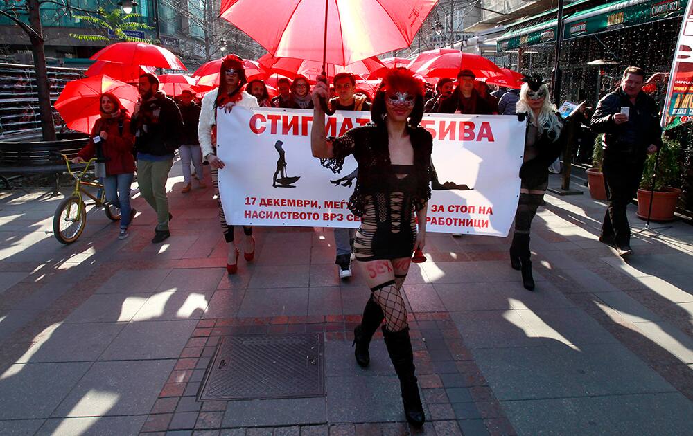 People carrying red umbrellas march through downtown Skopje, Macedonia, marking the International Day to End Violence Over Sex Workers.