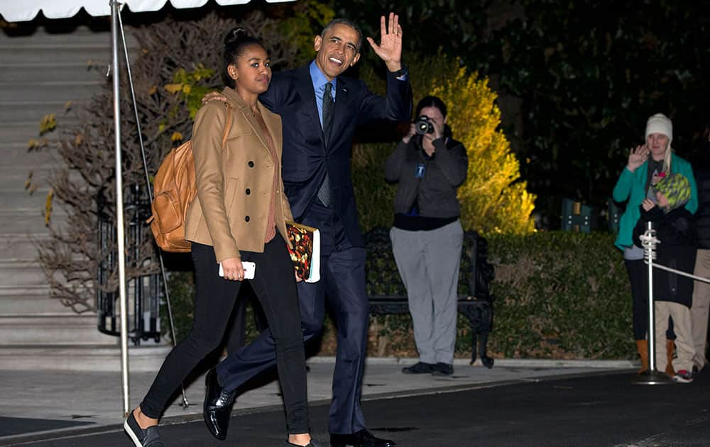 President Barack Obama waves as he and his daughter Sasha walk from the White House to board Marine One, in Washington, for the short trip to Andrews Air Force Base en route to San Bernardino, Calif.