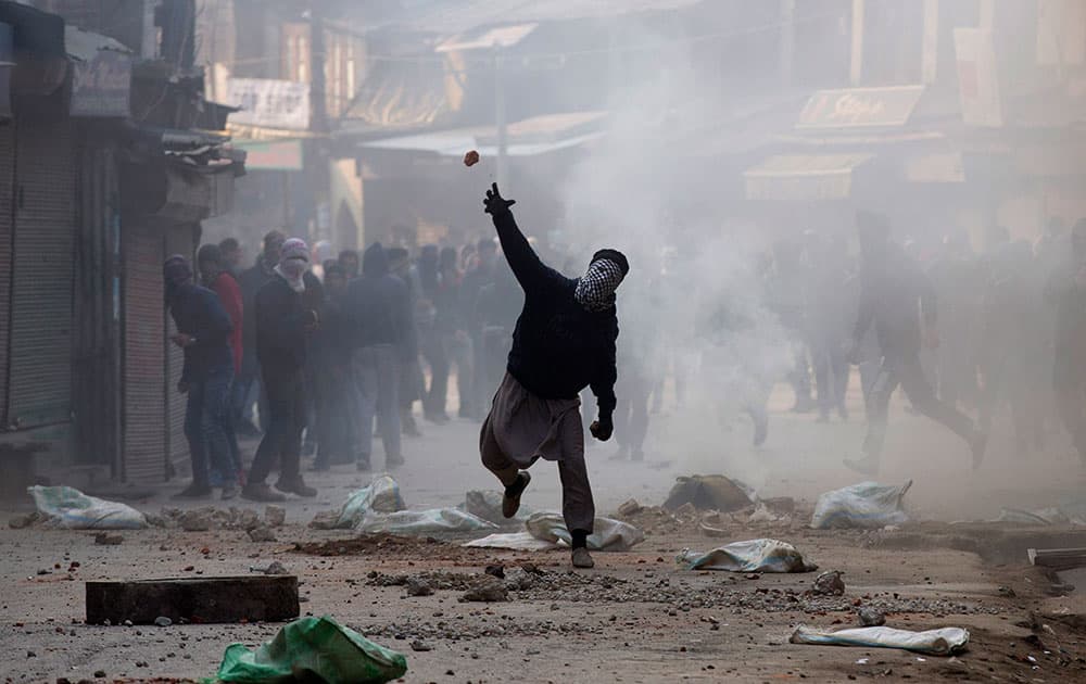 A Kashmiri Muslim protester throws stones at Indian security personnel in Srinagar.