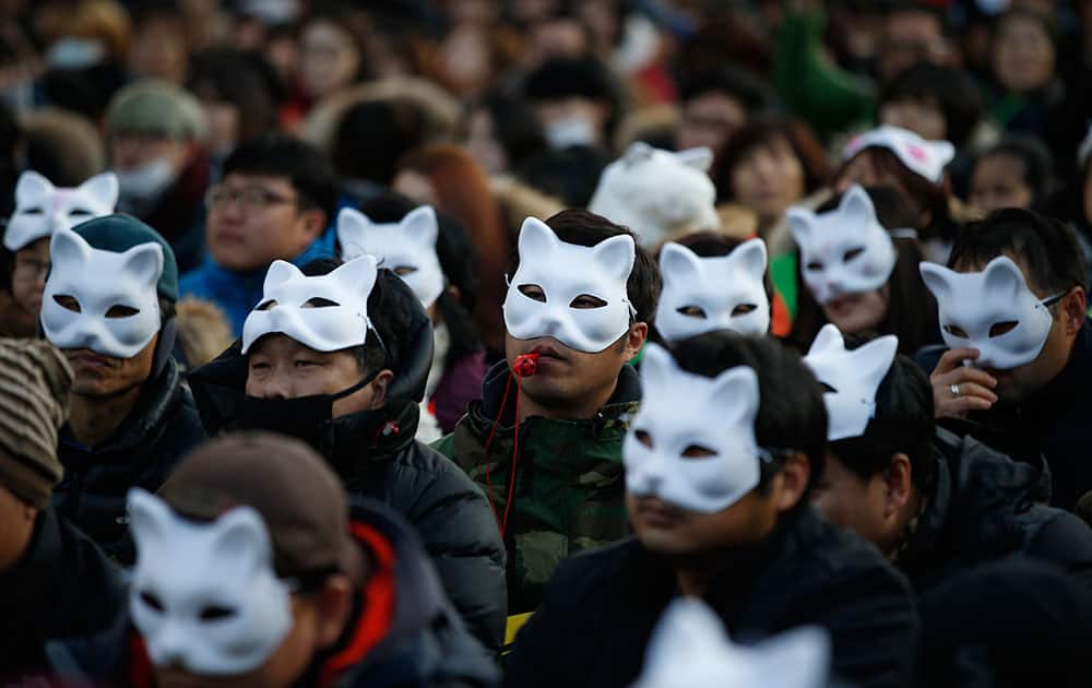 South Korean protesters wearing half masks attend an anti-government rally in downtown Seoul, South Korea.